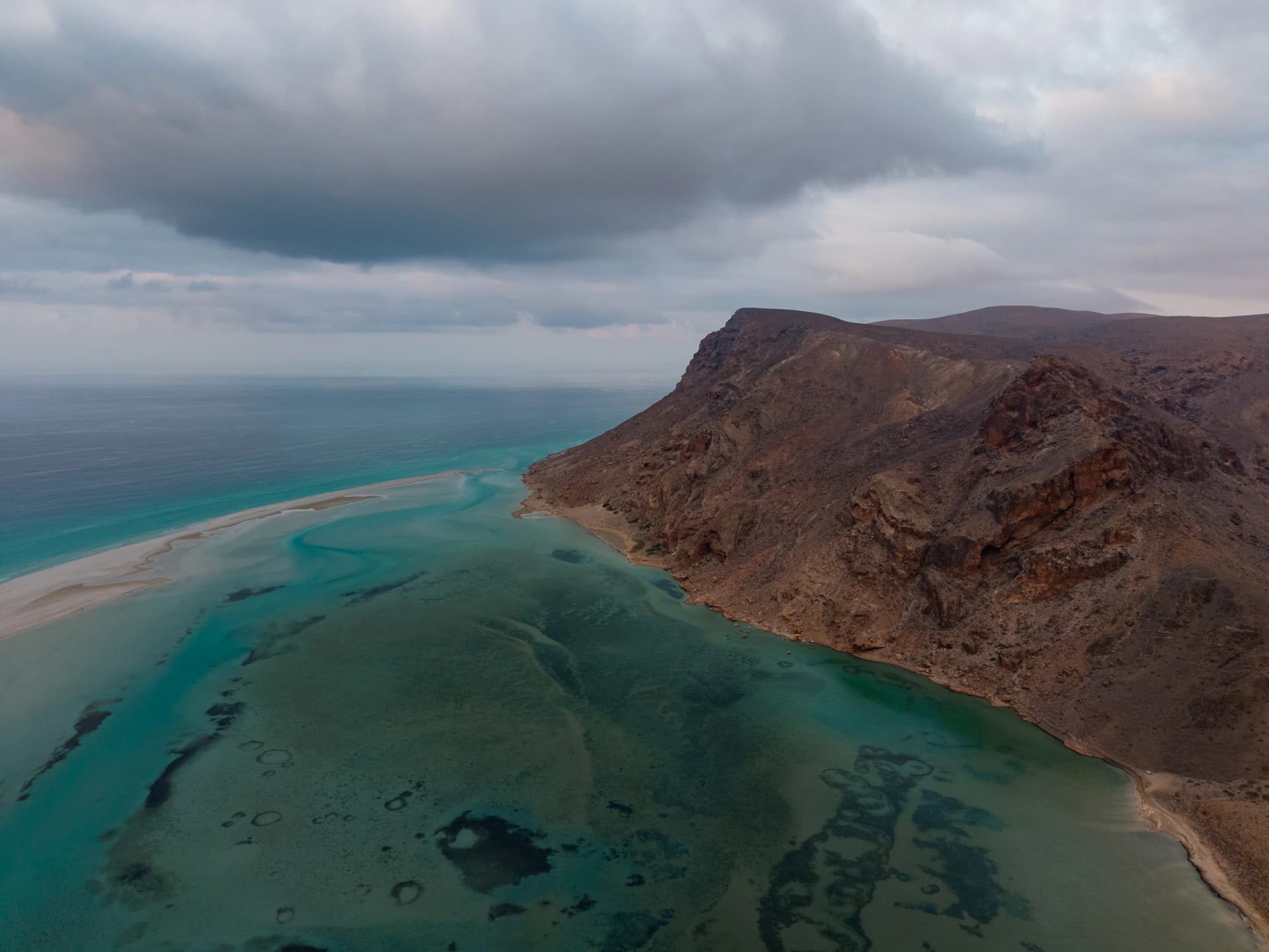 Aerial view of pale dunes meeting the turquoise water of Detwah Lagoon